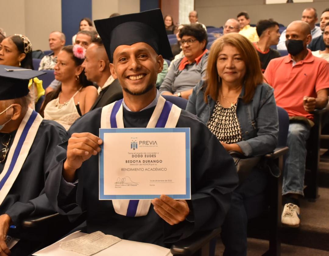Habitante de y en calle posa mostrando su diploma de bachiller