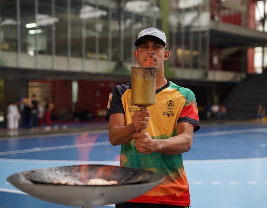 Deportista teniendo el fuego olímpico en los Juegos Deportivos y Recreativos de las Personas con Discapacidad